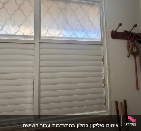 חלון עם תריסים סגורים בחדר אמבטיה